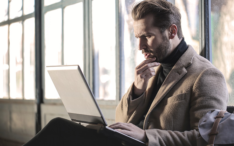 Man concerned looking at laptop